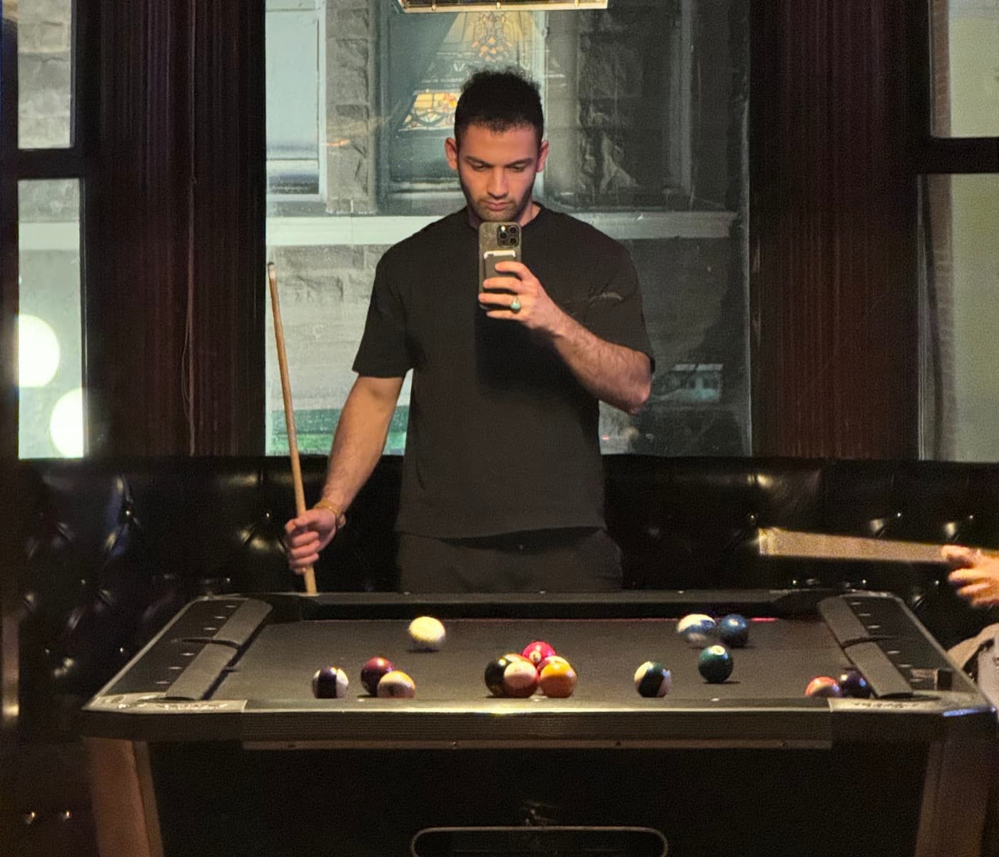 Mohammad lining up a shot at a billiards table